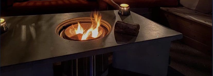 Outdoor round fire pit in the middle of a table.