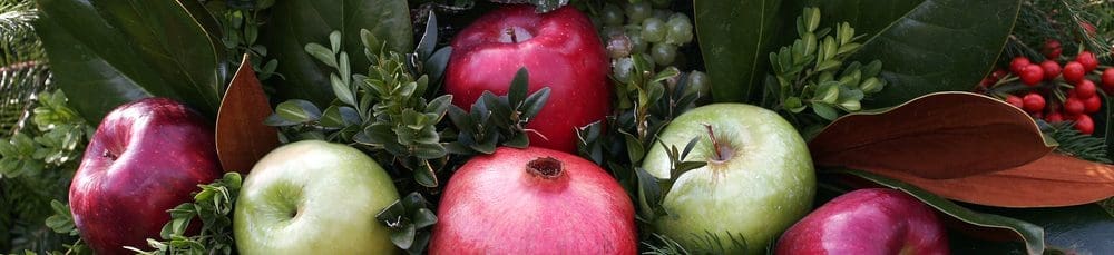 Winter greenery display of fruits as a centerpiece.